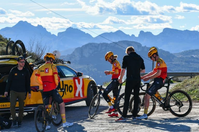 Uno-X-ryttere gjør seg klare ved lagbilen med fjellene på Costa Blanca i bakgrunnen
