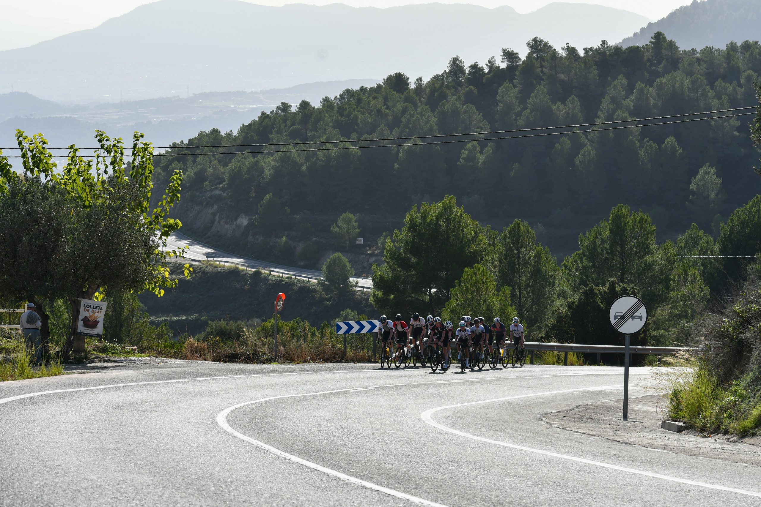 Gruppe med landeveissyklister i en sving på fjellvei med utsikt over dalen på Costa Blanca