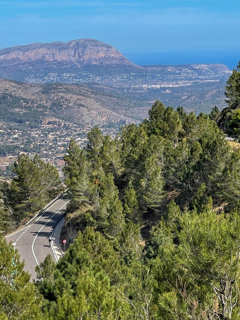 Svingete vei gjennom furuskog med utsikt mot Montgó og havet