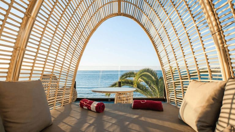 Sofa med havutsikt og palmer på terrassen hos SOLYMAR Gran Hotel i Calpe