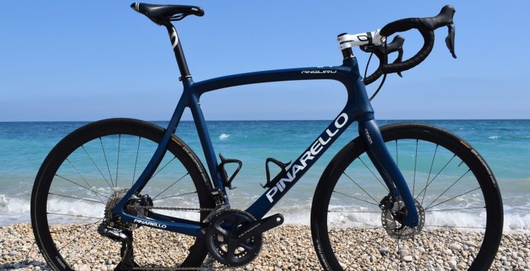 Pinarello-racersykkel fra TopBikes på en rullesteinstrand ved Altea